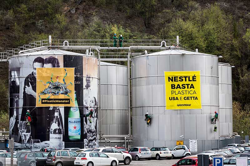 Attivisti di Greenpeace con un mostro di plastica davanti alla fabbrica Nestlè
